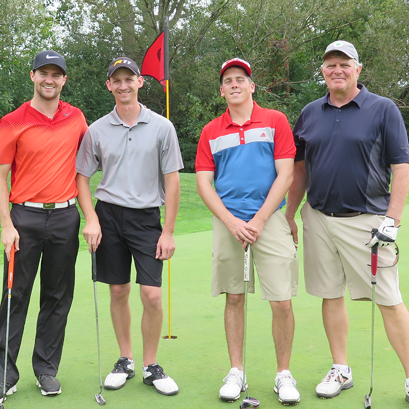 golfers standing by golf hole with flag